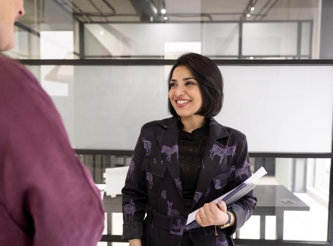 Woman talking with colleague in hallway